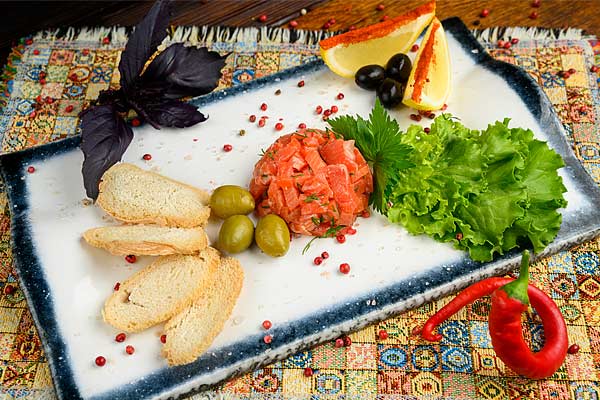 Лосось слабосолёный. Подаётся с лимоном, маслинами и оливками.